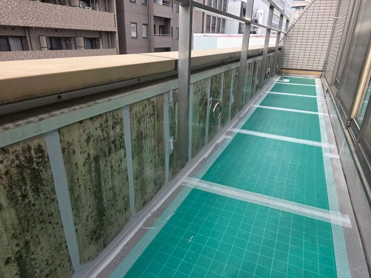防水を施工したベランダ通路。緑色の防水層が通路一面に仕上げられている