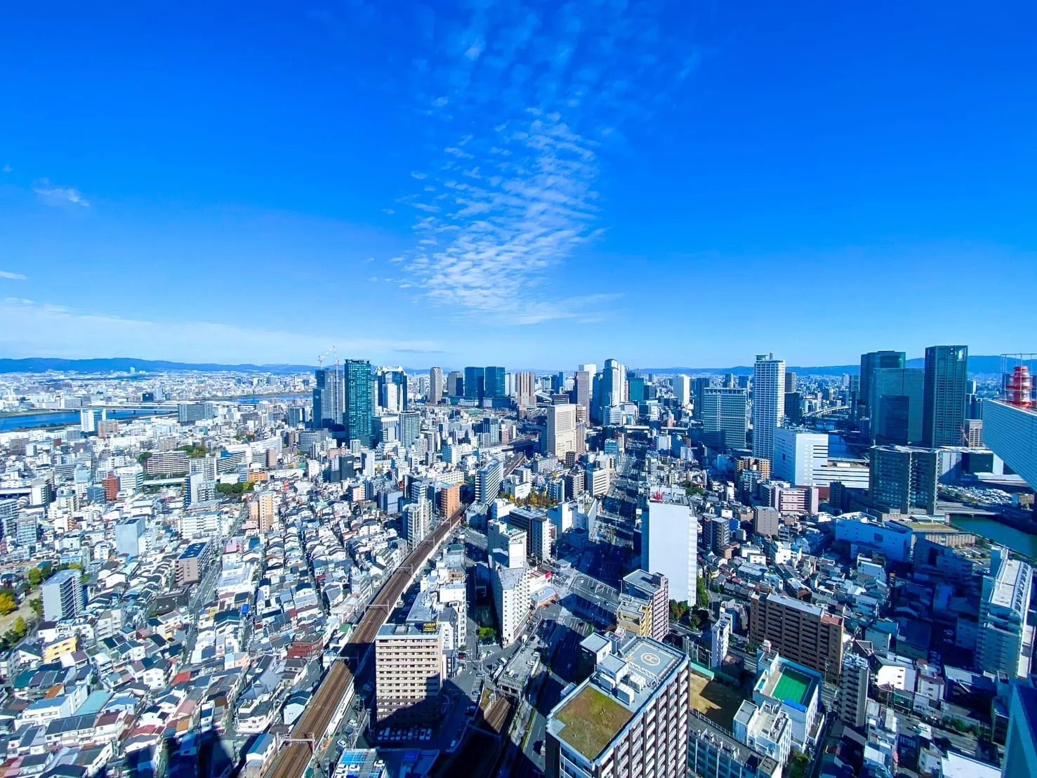タワーマンションの高層階から見下ろした大阪の街並みと青空